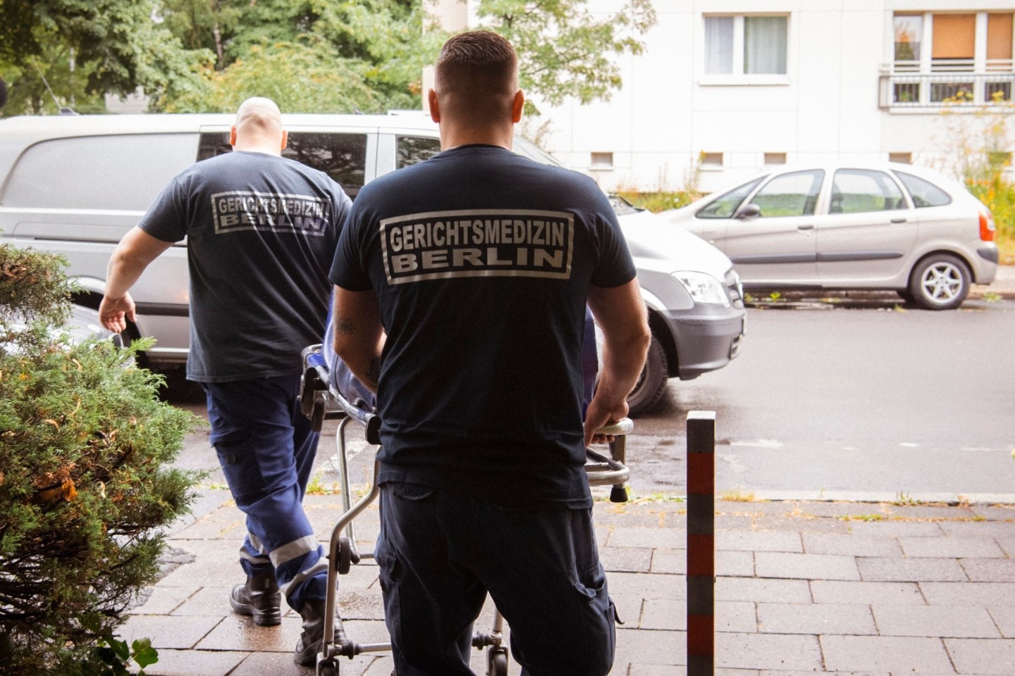 Mitarbeiter der Gerichtsmedizin holen eine Leiche aus einer Wohnung eines Mehrfamilienhauses in Berlin.